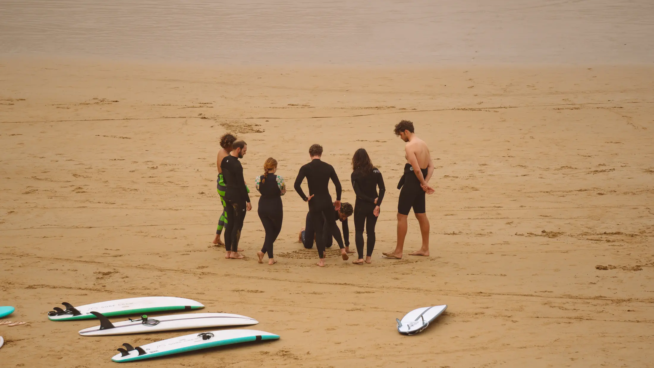 A surf group gathering for coaching on the beach